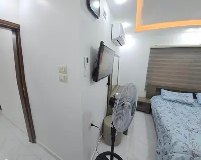 a room with a bed and a fan and a tv at اربد لواء الوسطية كفرعان مجسم البتراء