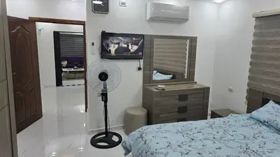 a bedroom with a bed and a mirror and a fan at اربد لواء الوسطية كفرعان مجسم البتراء