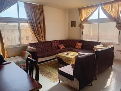 a living room with a couch and a table at Hana Home in Amman