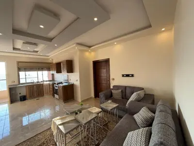a living room with a couch and a table at شقه للإيجار عجلون -رأس منيف in Ajloun