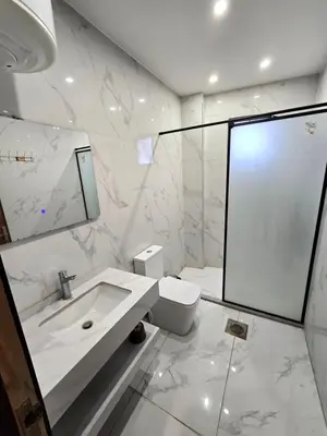 a white bathroom with a sink and a mirror at الياقوت للشقق الفندقية