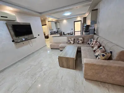 a large living room with a couch and a tv at الياقوت للشقق الفندقية