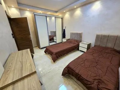 a hotel room with two beds and a mirror at الياقوت للشقق الفندقية