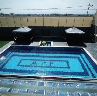 a large swimming pool sitting next to a building at Qubaisi chalet in Al Rama