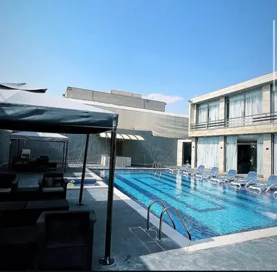 a large swimming pool with chairs and a building at Qubaisi chalet in Al Rama