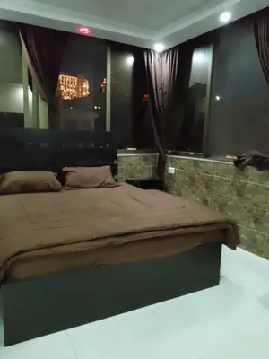 a bedroom with a large bed and a mirror at شقق تلاع العلي in Amman