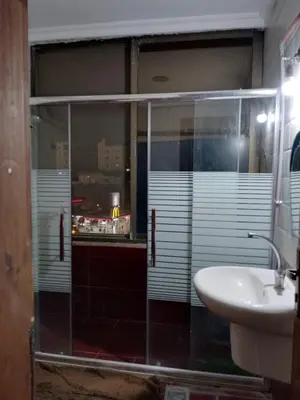 a bathroom with a glass shower and a sink at شقق تلاع العلي in Amman
