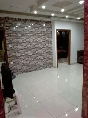 a room with a stone wall and a white tile floor at شقق تلاع العلي in Amman