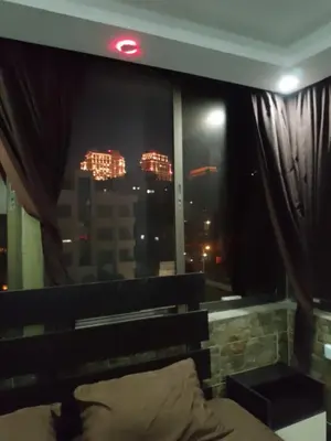 a bedroom with a view of a city at night at شقق تلاع العلي in Amman