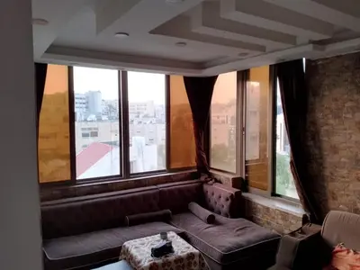 a living room with a couch and some windows at شقق تلاع العلي in Amman