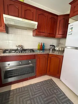 a kitchen with a stove and a refrigerator at Welcome to our prime location flat in Amman