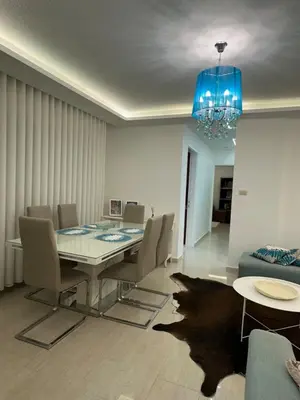 a dining room with a table and a blue chandelier at Welcome to our prime location flat in Amman