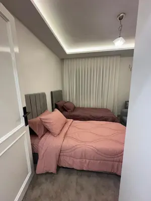 a bedroom with two beds with pink sheets at Welcome to our prime location flat in Amman