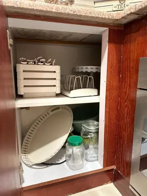 a cupboard with a mirror and dishes in it at Welcome to our prime location flat in Amman