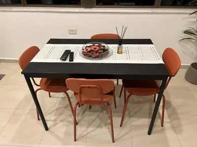 a black table with orange chairs and a bowl of fruit at 7th Circle 1 bedroom flat Amman, pleasant views in Amman