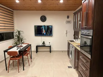 a kitchen with a table and a tv on the wall at 7th Circle 1 bedroom flat Amman, pleasant views in Amman