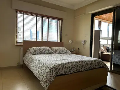 a bedroom with a bed and a large window at 7th Circle 1 bedroom flat Amman, pleasant views in Amman