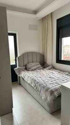 a large bed in a bedroom with a window at Furnished Apartment in Bushrá