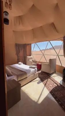 a bedroom with a bed and a view of the desert at A luxurious experience under the stars of Wadi Rum in Wadi Rum