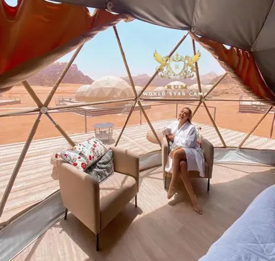 a woman sitting in a chair in a tent at Wadi rum magic Luxury in Wadi Rum