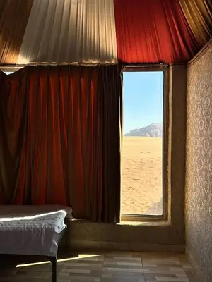a bedroom with a bed and a window in the desert at Star Gate Camp in Wadi Rum