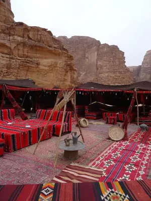 a tent with red chairs and a table in the desert at Hillawi Private Bedouin Camp in Wadi Rum