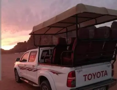 a white truck with a roof rack on the beach at Ram Camp Desert in Wadi Rum