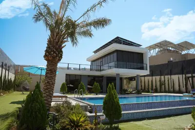 a villa with a palm tree and a swimming pool at Atlantis The Palm Villa in Al Rama