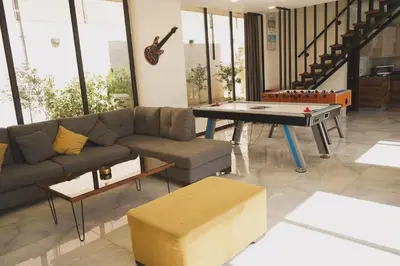 a living room with a couch and a ping pong table at Atlantis The Palm Villa in Al Rama