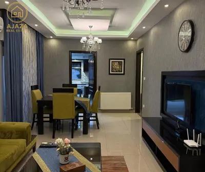 a living room with a couch and a dining room at Ajaza Real Estate in Amman
