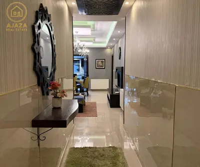 a hallway with a mirror and a table in a room at Ajaza Real Estate in Amman