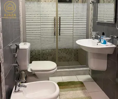 a bathroom with a toilet and a sink and a shower at Ajaza Real Estate in Amman