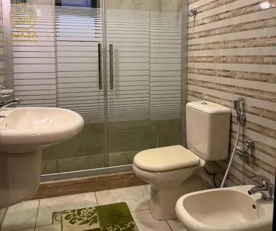 a bathroom with a toilet and a sink and a shower at Ajaza Real Estate in Amman