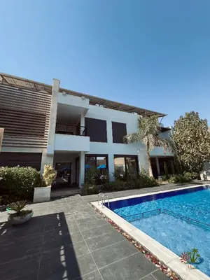 a house with a swimming pool in front of it at Mirabella Villa in Al Rama