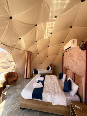 a bedroom with two beds in a tent at Luxury Camp Wadi Rum in Disah