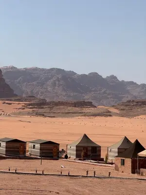 a group of huts in the middle of a desert at Luxury Camp Wadi Rum in Disah