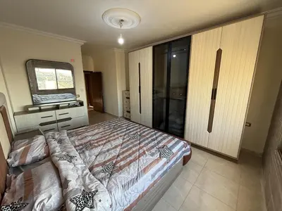 a bedroom with a large bed and a mirror at شقة للإيجار في عجلون in Ajloun