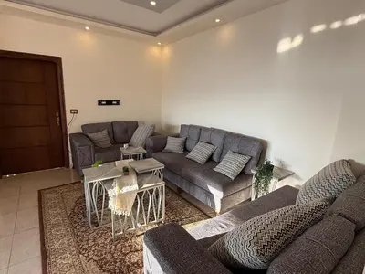 a living room with two couches and a table at شقة للإيجار في عجلون in Ajloun