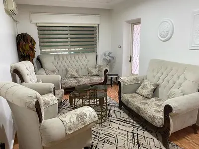 a living room with a couch and chairs and a table at jawharet el ordon in Amman