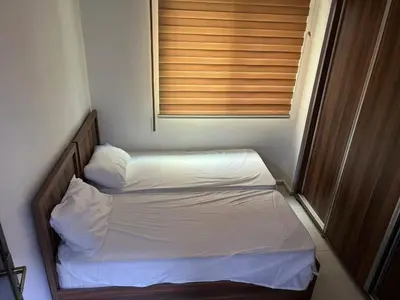 a small bedroom with two beds and a window at jawharet el ordon in Amman