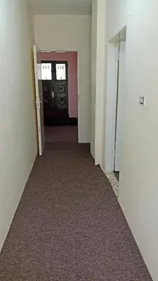 an empty hallway with a door and a carpeted floor at عجلون اشتفينا in Ajloun