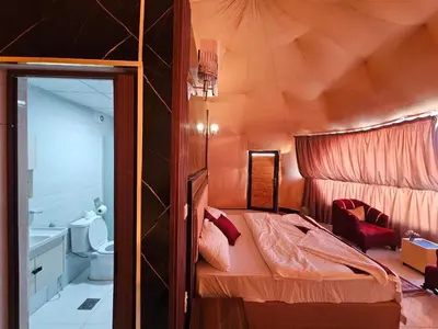 a bedroom with a bed and a toilet in a room at LONAR LORE lUXURY CAMP in Disah