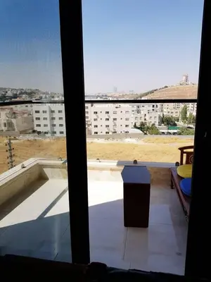 a view of a building from a window with a trash can at Luxury 3 bedrooms flat with great view of Amman in Amman