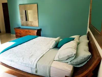 a large bed in a bedroom with a blue wall at Luxury 3 bedrooms flat with great view of Amman in Amman