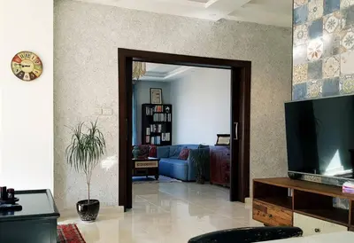 a living room with a blue couch and a television at Luxury 3 bedrooms flat with great view of Amman in Amman
