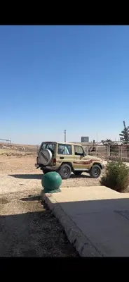 a jeep parked in a parking lot in the desert at البترا Petra in Abū al Lasan