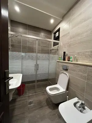 a bathroom with a toilet and a sink and a shower at 3BR Escape with Outdoor Scenic Views in Amman