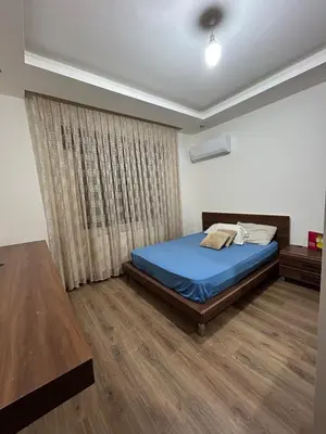 a bedroom with a blue bed and a window at 3BR Escape with Outdoor Scenic Views in Amman