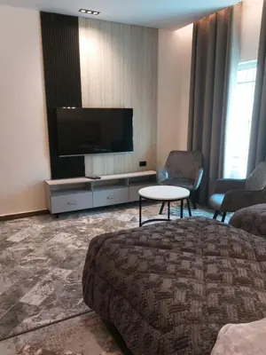 a hotel room with a tv and a bed and a table at رياحين الخلود in Amman