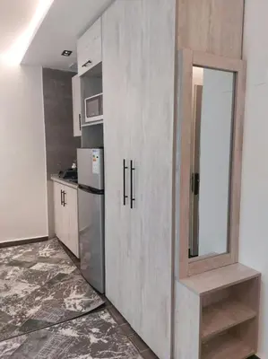 a kitchen with a large wooden cabinet with a mirror at رياحين الخلود in Amman